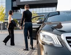 Executive chauffeur opening car door in Manchester